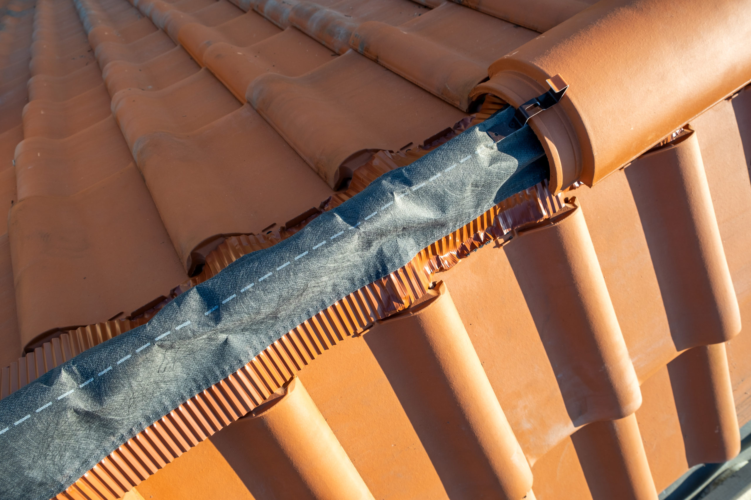 Closeup of yellow ceramic roofing ridge tiles on top of resident
